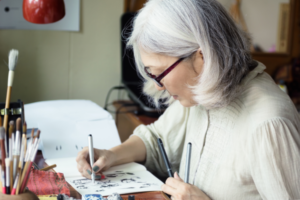 Older adult drawing with a pen